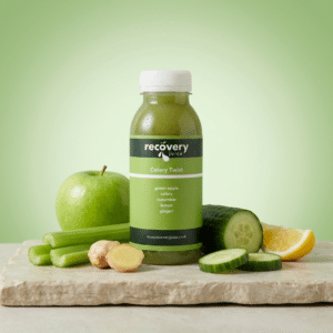 Celery Twist cold-pressed green juice with celery, apple, cucumber, lemon and ginger on stone slab with light green background