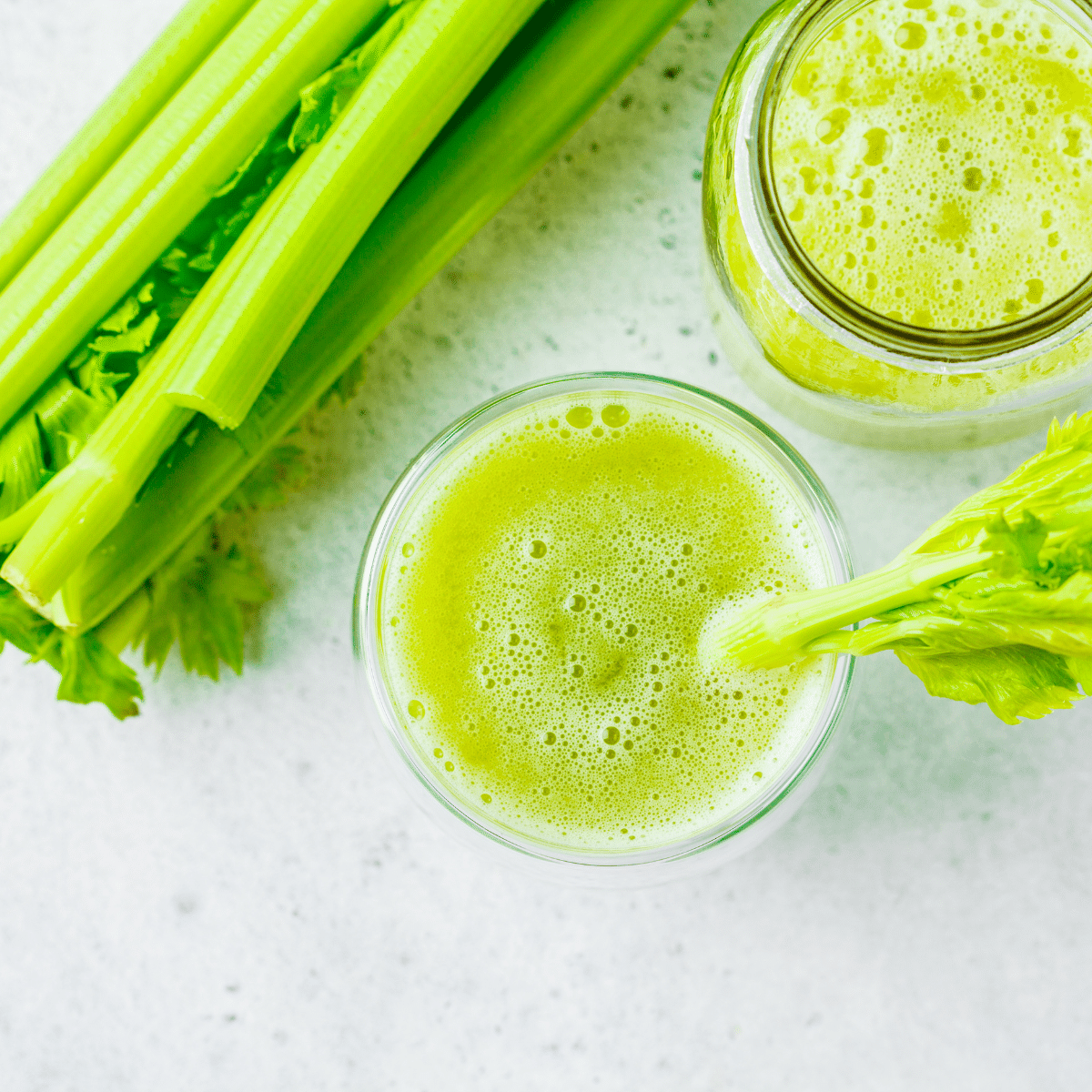 Fresh celery juice in a glass with stalks – natural benefits for digestion, bloating and hydration