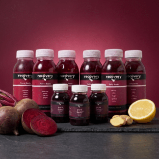 Cold-pressed beetroot juice bundle with Daily Beets, Power Beets and Pure Beets bottles on slate with fresh beetroot, ginger and lemon