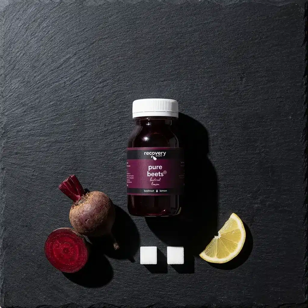 A bottle of Pure Beets cold-pressed beetroot juice beside two sugar cubes and a raw beetroot