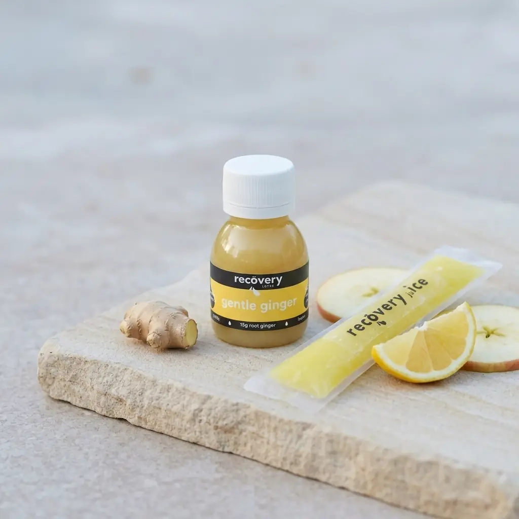 Fresh ginger root with lemon, apple and simple ginger ice pops on a calm pale surface, a gentle cold option for queasy days